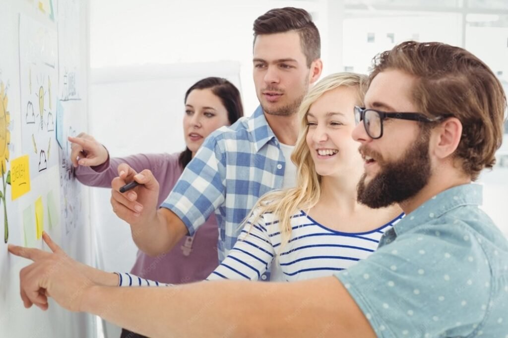 Jeunes professionnels collaborant devant un tableau blanc