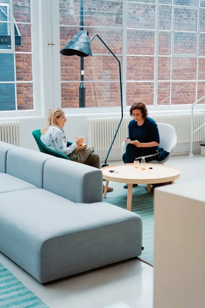 Deux femmes discutent dans un salon moderne lumineux